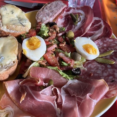 Assiette composée de charcuterie et fourme de Montbrison AOP fondue sur tartine