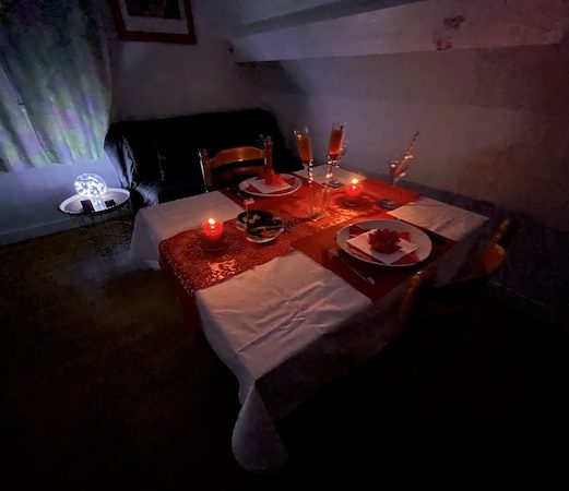 Ambiance rouge et blanche sur table pour amoureux, romantisme et chandelles, rideaux verts et rose