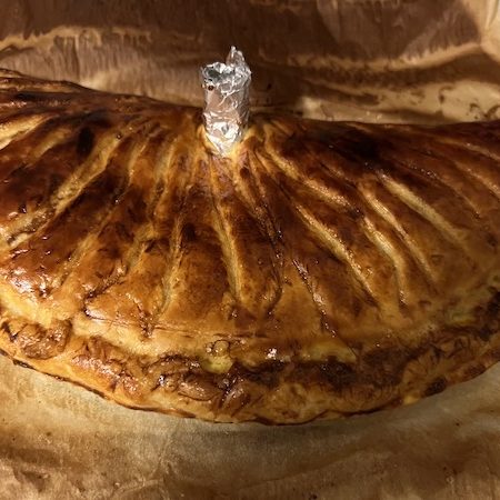 La tourte jambon champignons du Forez Demi tourte dorée sortie du four avec cheminée en papier aluminium au centre