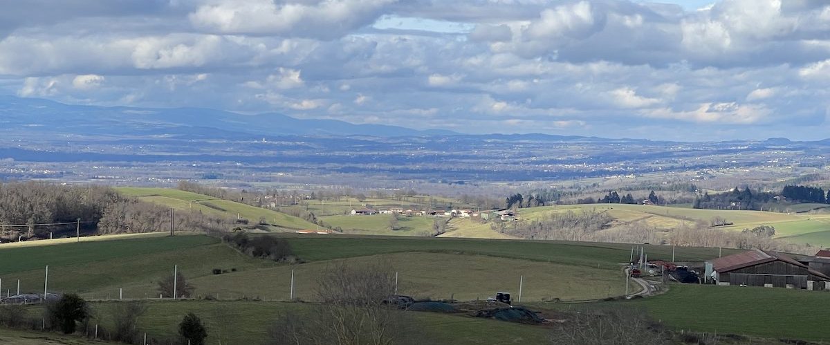 Chemins de randonnée dans les Monts du Lyonnais avec vue panoramique, paysage verdoyant et naturel