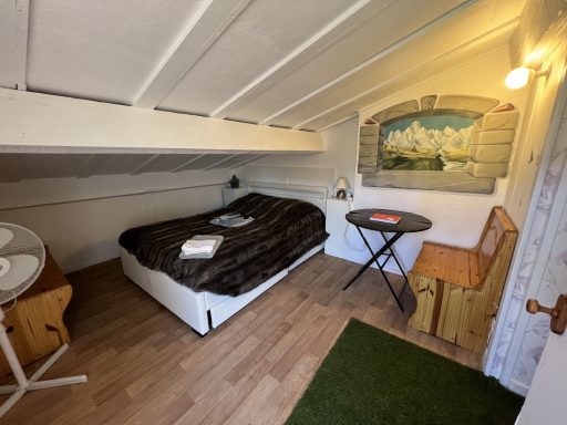 Chambre mansardée blanche avec lit double dans l'espace enfants de la chambre Chevrefeuille