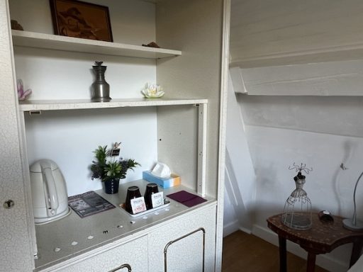 L'armoire bibliothèque blanche avec plateau d'accueil et décorations, vue sur chevet de lit