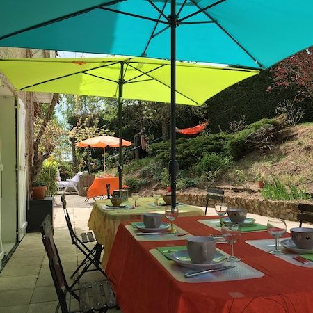 Six petits déjeuner servis en terrasse sous les parasols colorés, ambiance extérieure reposante à L'Escale du Loup Blanc