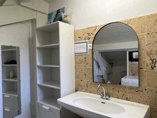 Vue sur la vasque et le meuble de rangement de la salle de bain carrelée de la chambre Perle à l'Escale du Loup Blanc