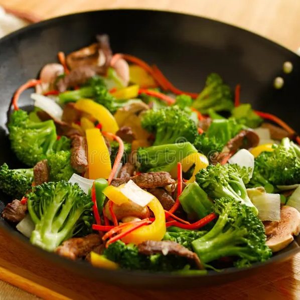 Wok de légumes frais croquants, parfumés au gingembre et aux herbes, servi à la table d'hôtes 