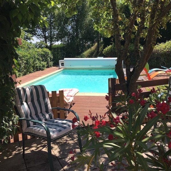 Une oasis de fraicheur dans le jardin fleuri Vue sur une maison blanche avec magnolia fleuri devant et ciel bleu intense