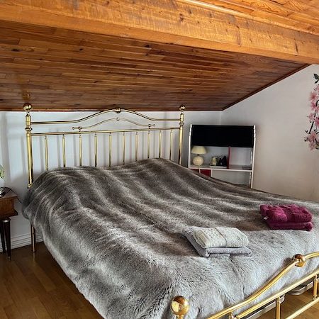 Vue sur le lit Queen de la suite recouvert d'un couvre-lit imitation peau de loup gris